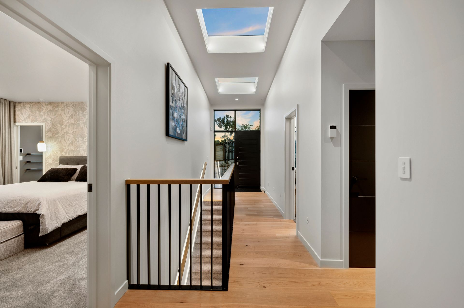 A hallway leading to a bedroom and stairs in a house.
