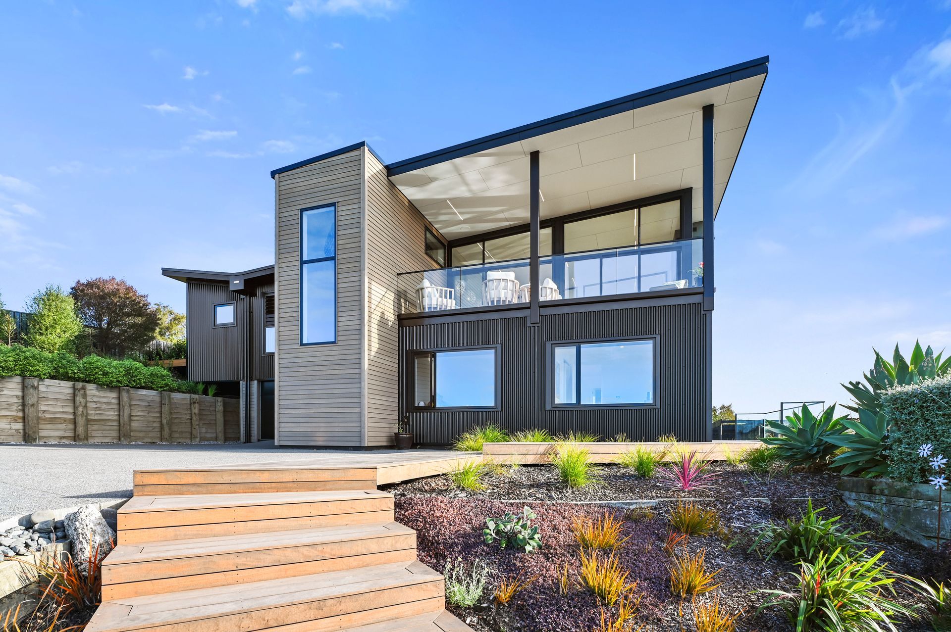 A large house with stairs leading up to it is sitting on top of a hill.