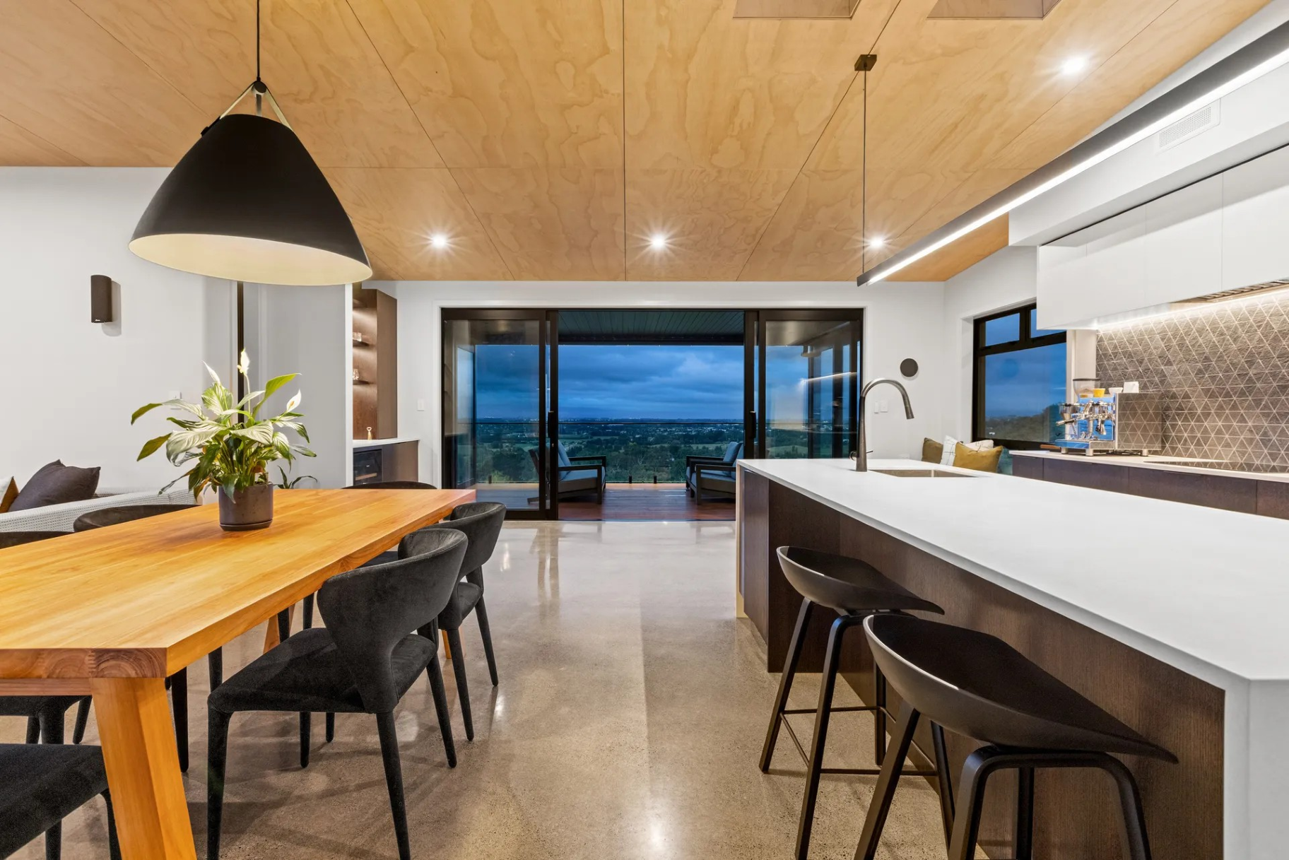 A kitchen and dining room in a house with a large table and chairs.
