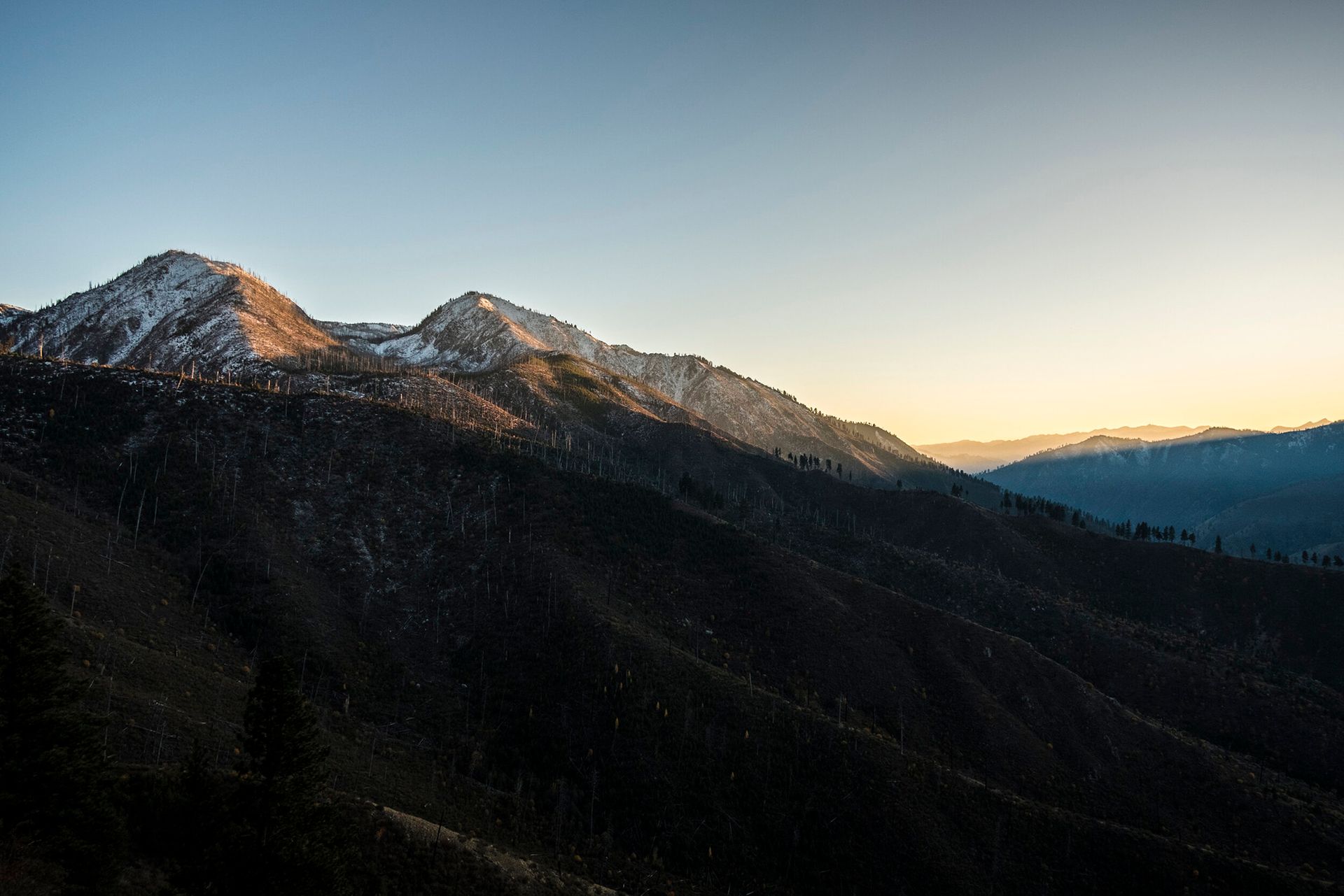Sunlight hits the snowy peaks at sunset in the Frank Church Wilderness