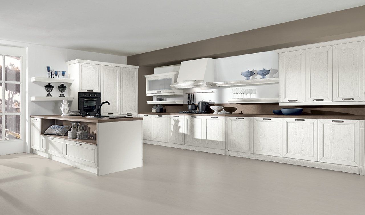 Una cucina con mobili bianchi e una grande isola al centro