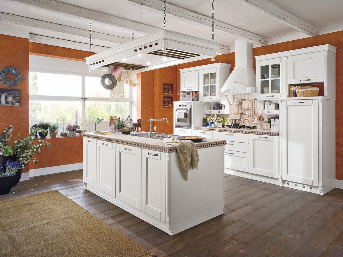 Una cucina con mobili bianchi e una grande isola al centro