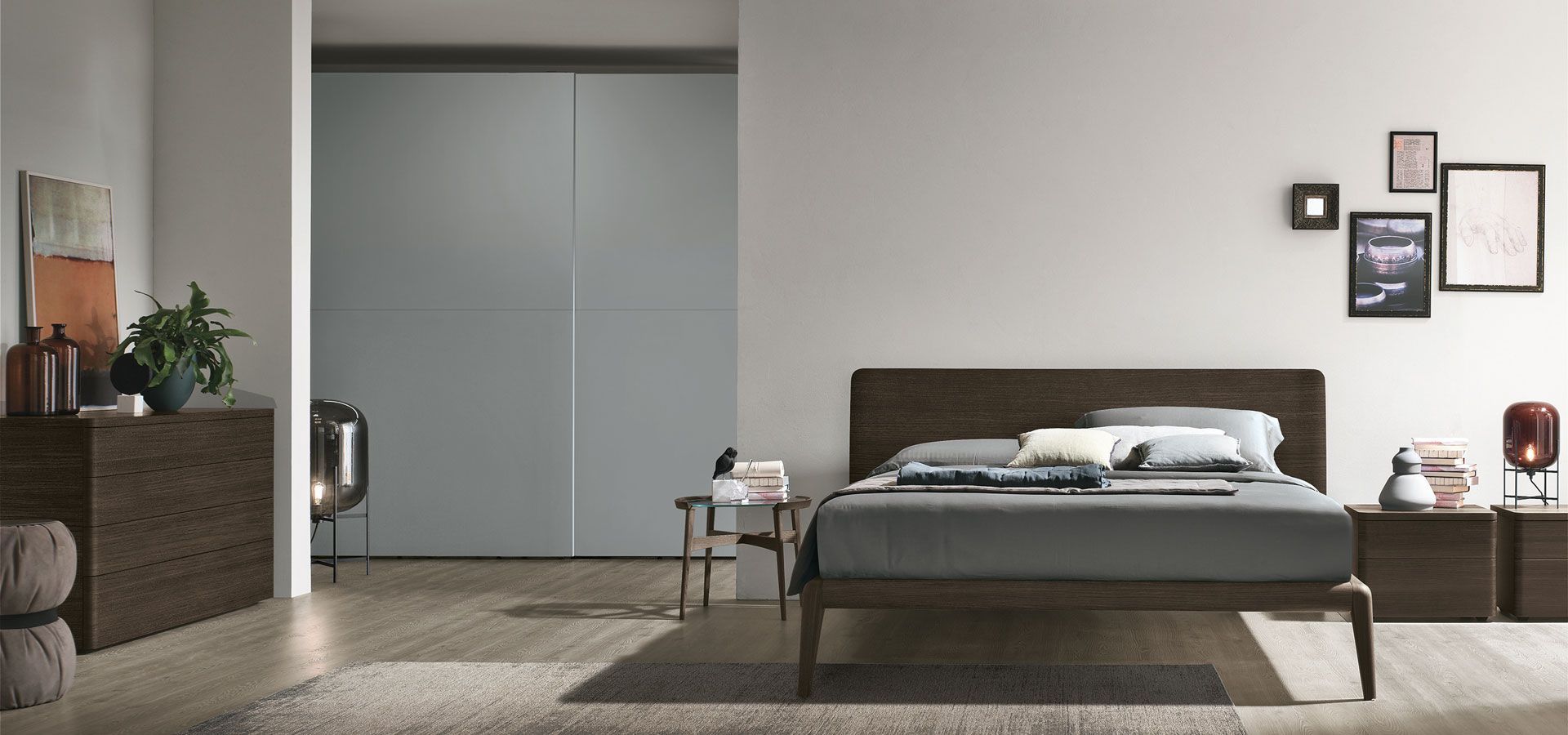 Una camera da letto con letto, cassettiera, comodino e porte scorrevoli.