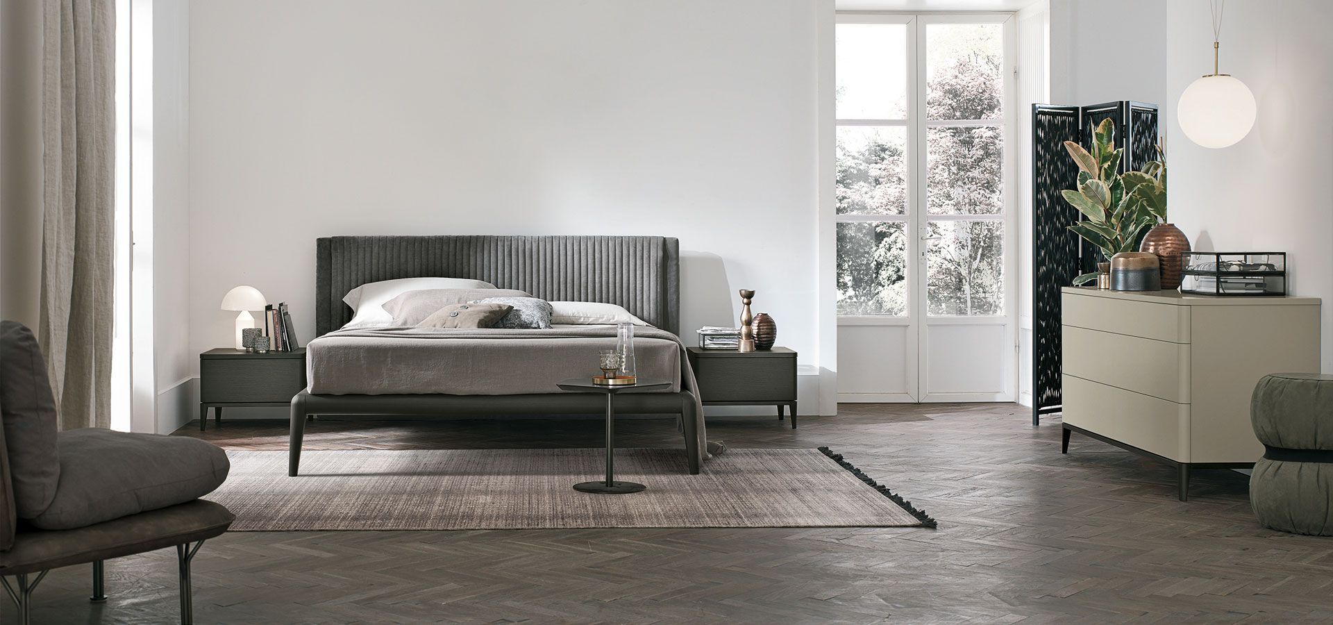 Una camera da letto con un letto, una cassettiera, una sedia e una finestra.