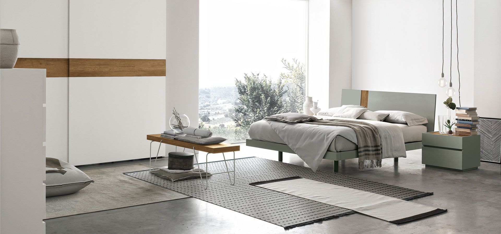 Una camera da letto con letto, comodino, tappeto e porte scorrevoli in vetro.