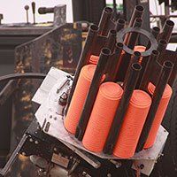 A clay pigeon shooting machine with orange clay targets.