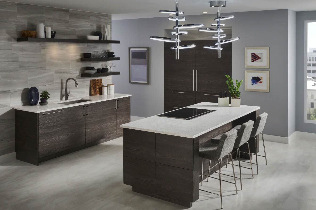 Modern kitchen with dark cabinetry, white countertops, and an island with seating.