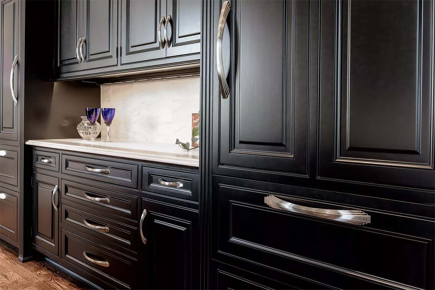 Black kitchen cabinets with silver hardware.