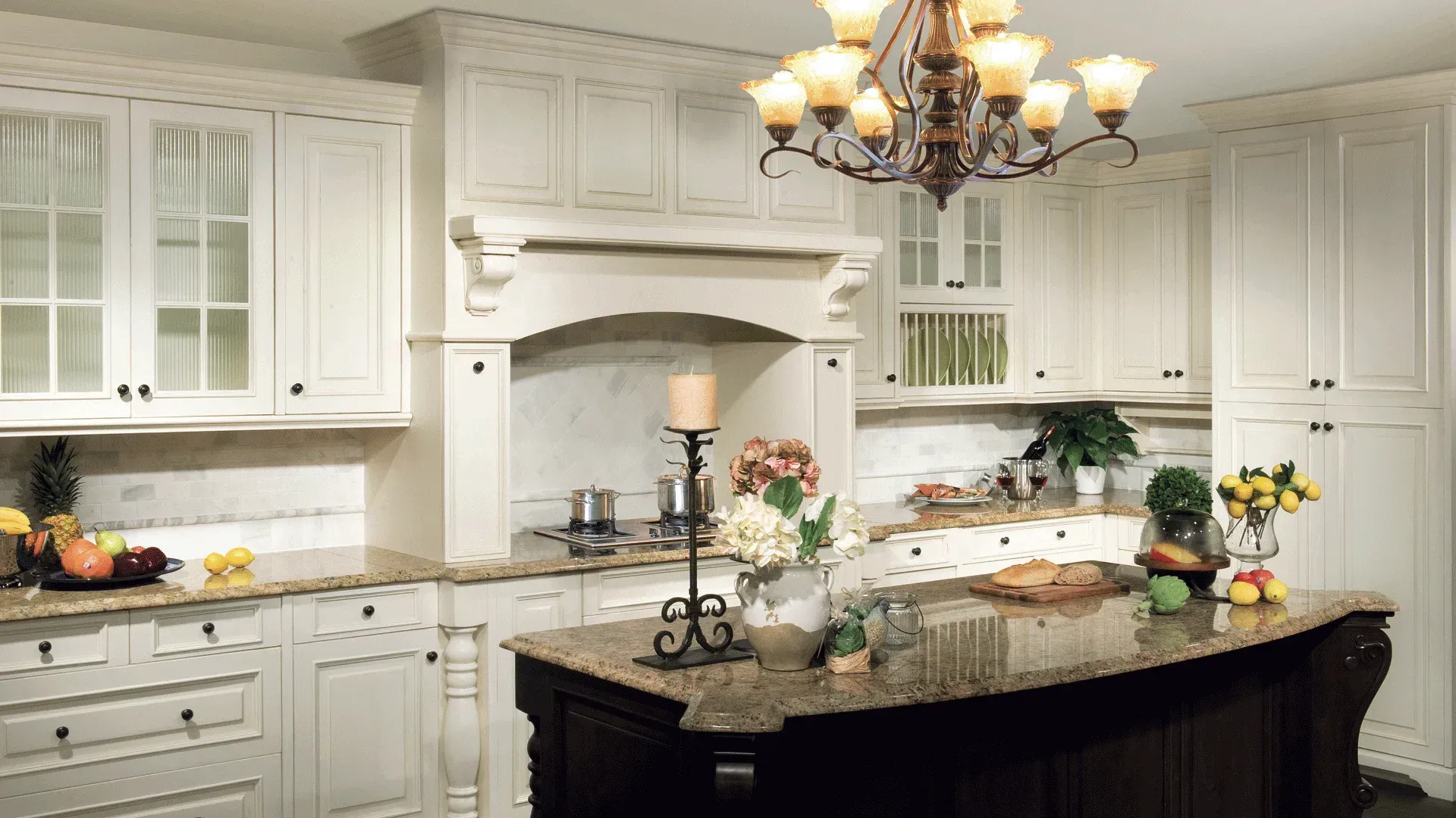 Elegant white kitchen with granite countertops and dark island.