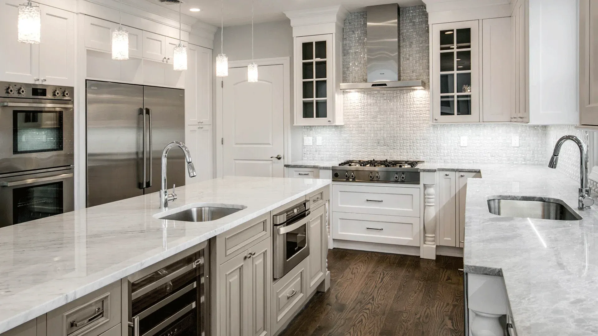 Luxurious white kitchen with island, stainless steel appliances, and marble countertops.