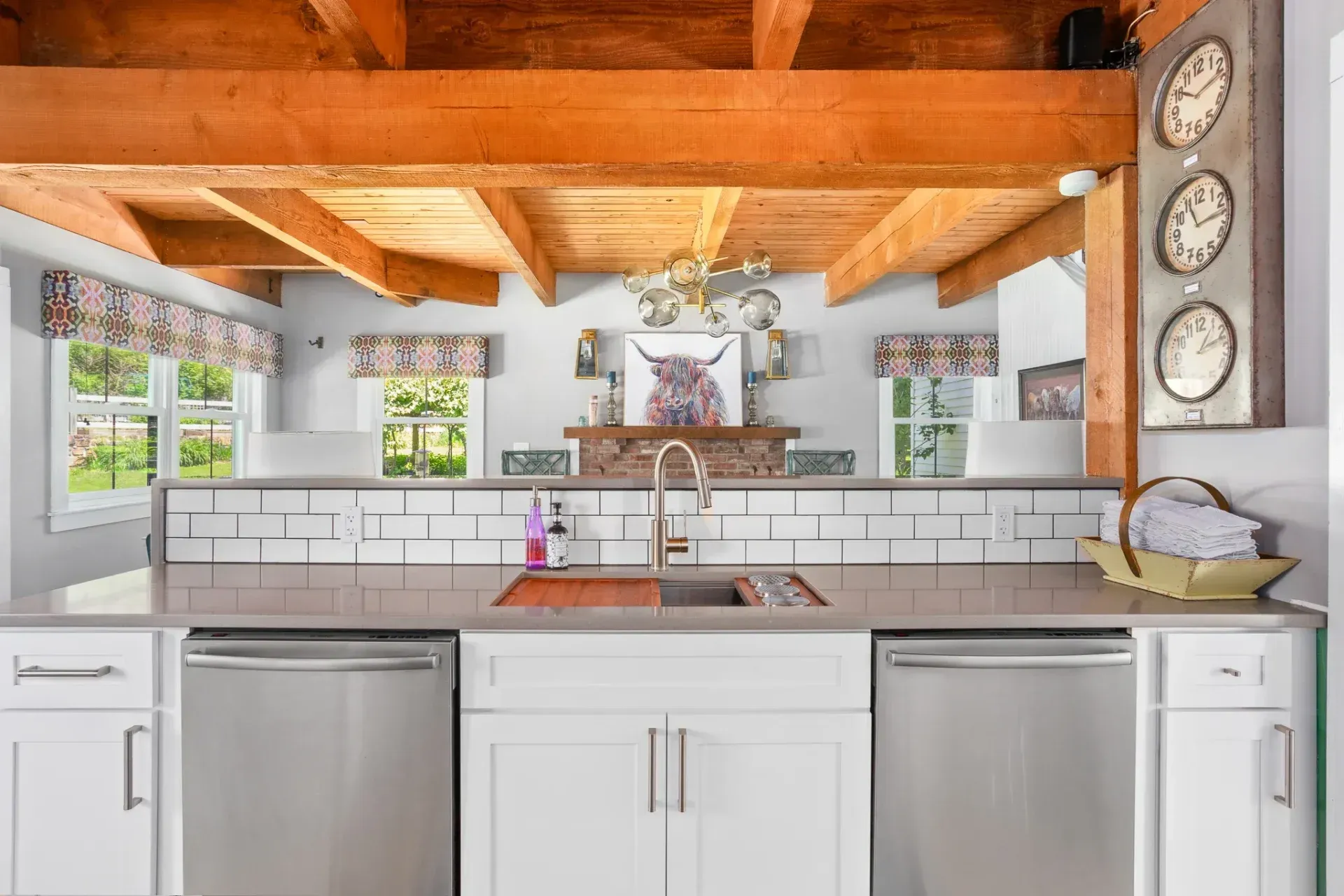 Kitchen with white cabinets, stainless steel appliances, and wood beam ceiling.