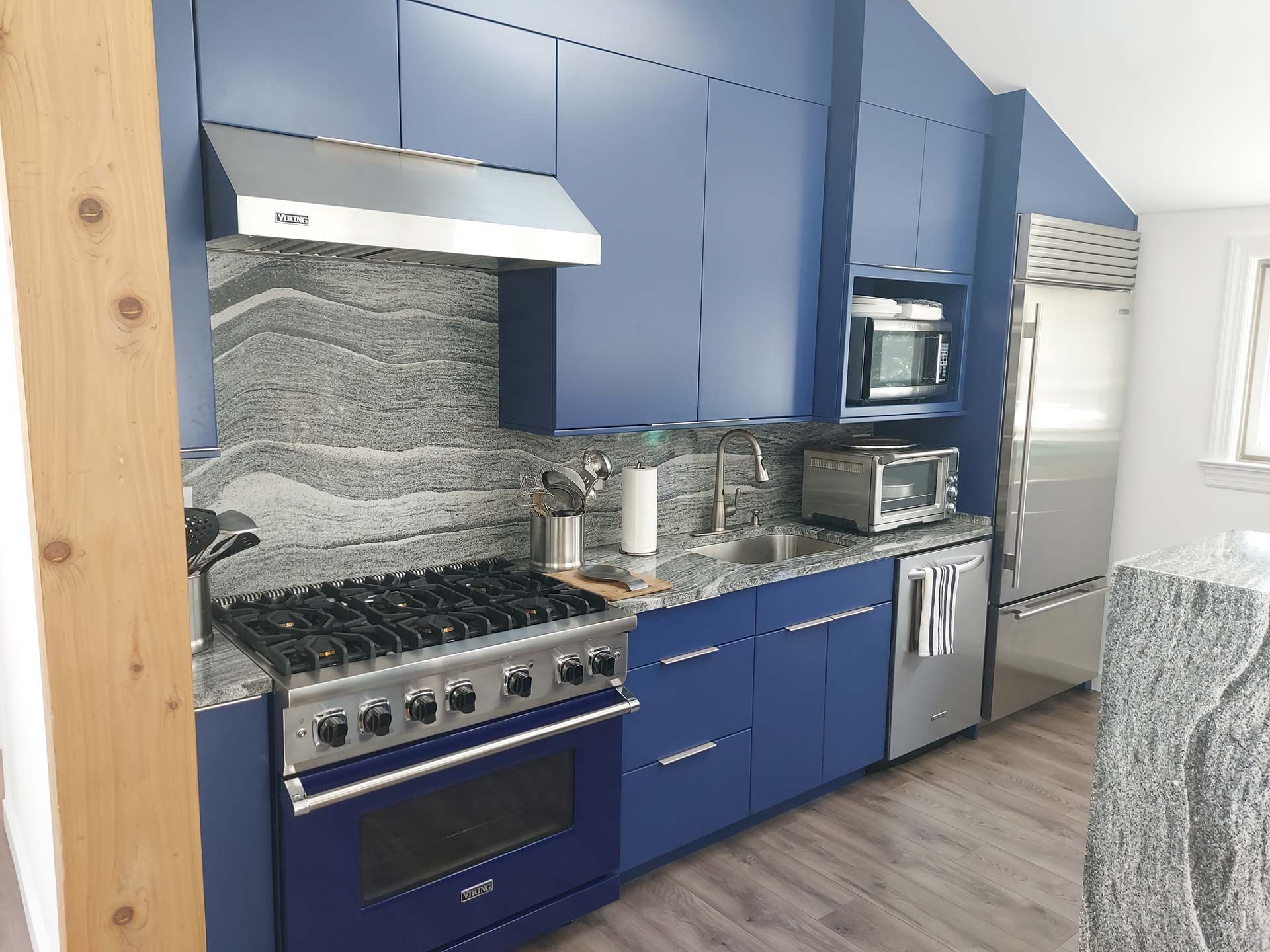 Blue kitchen with stainless steel appliances and granite countertops.