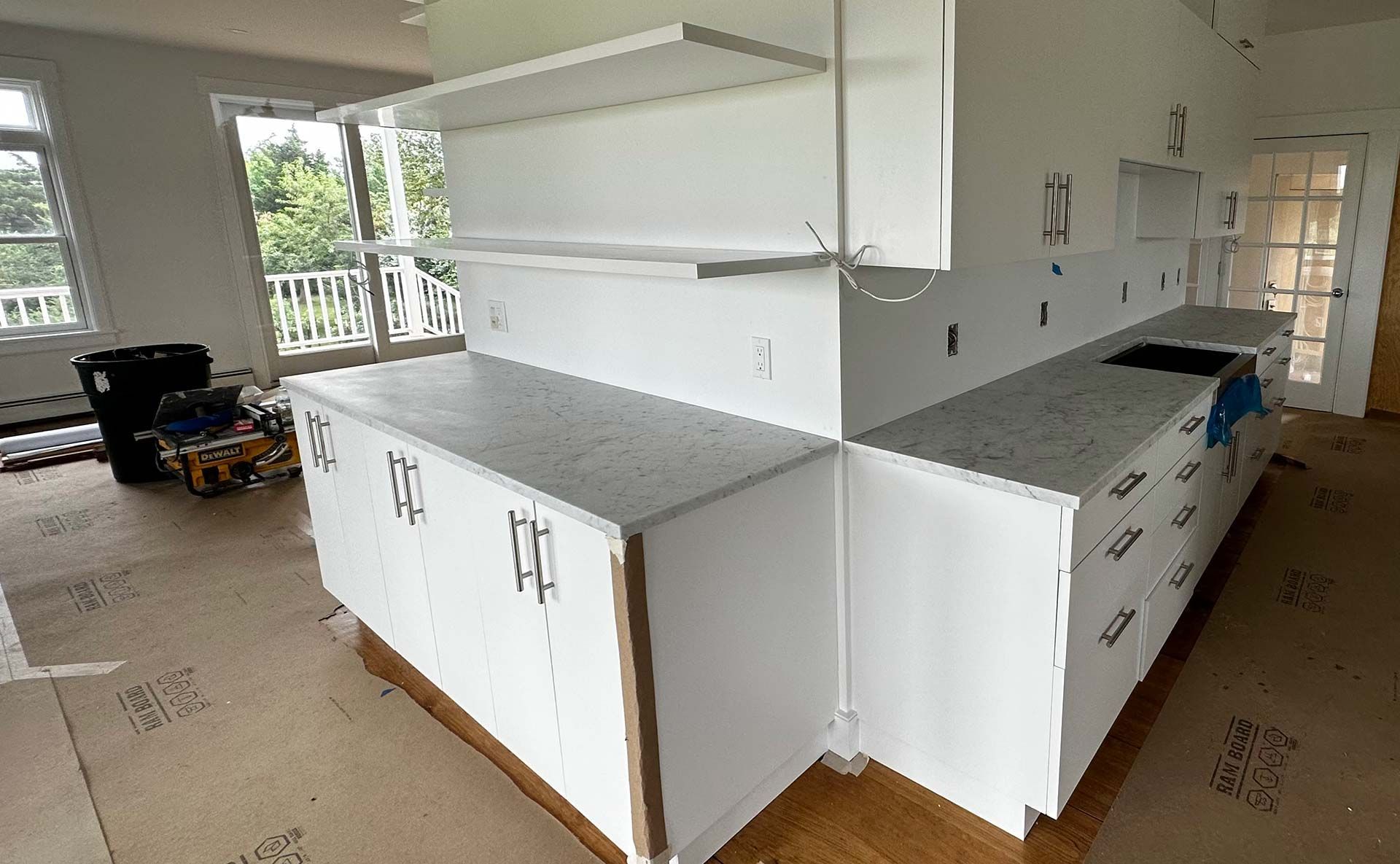 White kitchen cabinets and countertops under construction.
