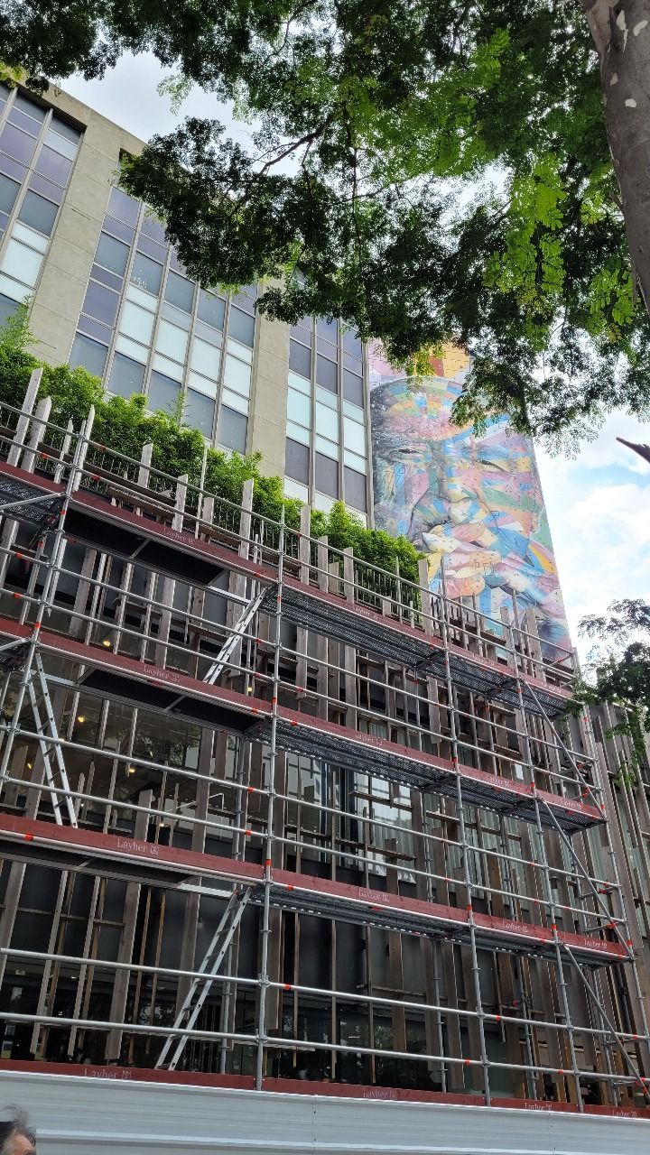 Dois edifícios modernos contra um céu azul com nuvens brancas.