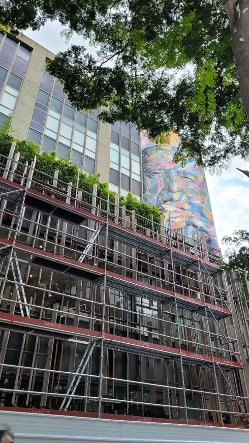 Dois edifícios modernos contra um céu azul com nuvens brancas.
