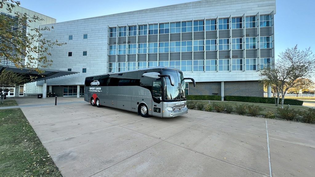 A large bus is parked in front of a large building.