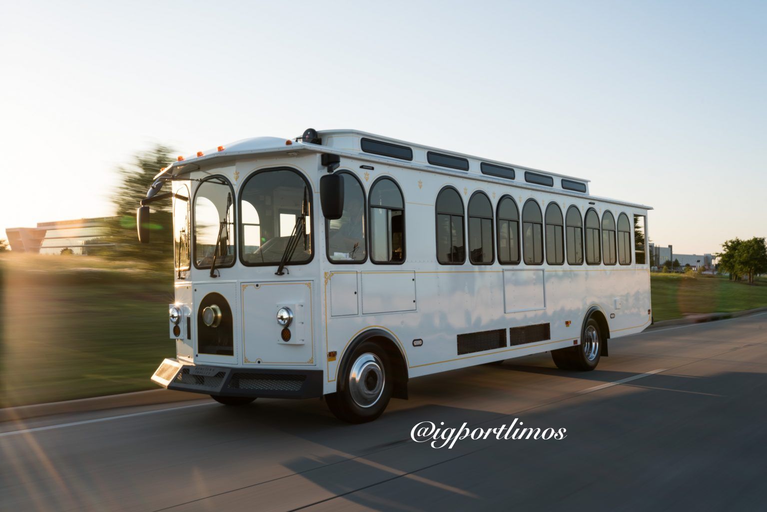 A white trolley bus is driving down a street.