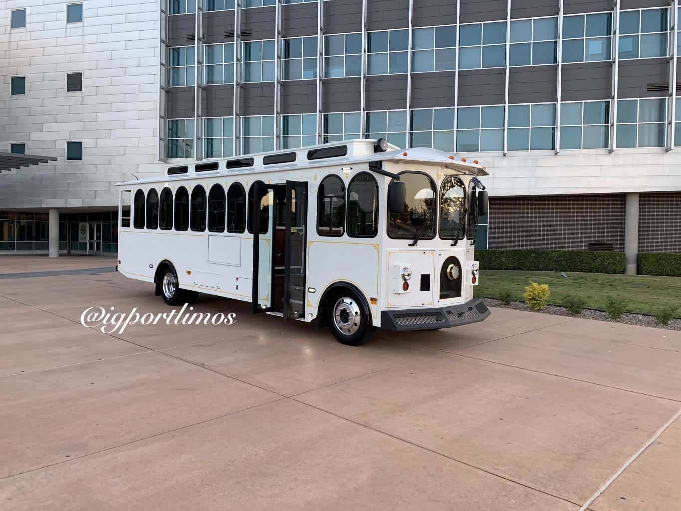 A white bus is parked in front of a building.