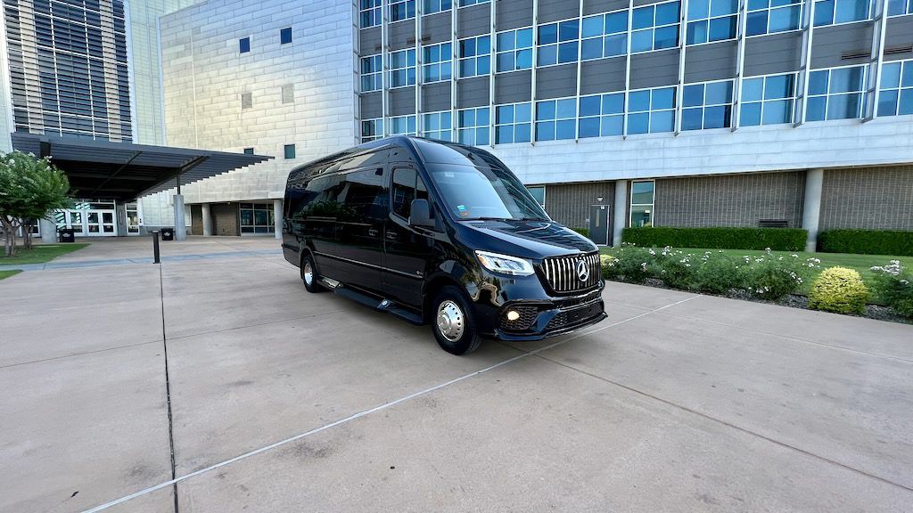 A black van is parked in front of a building.