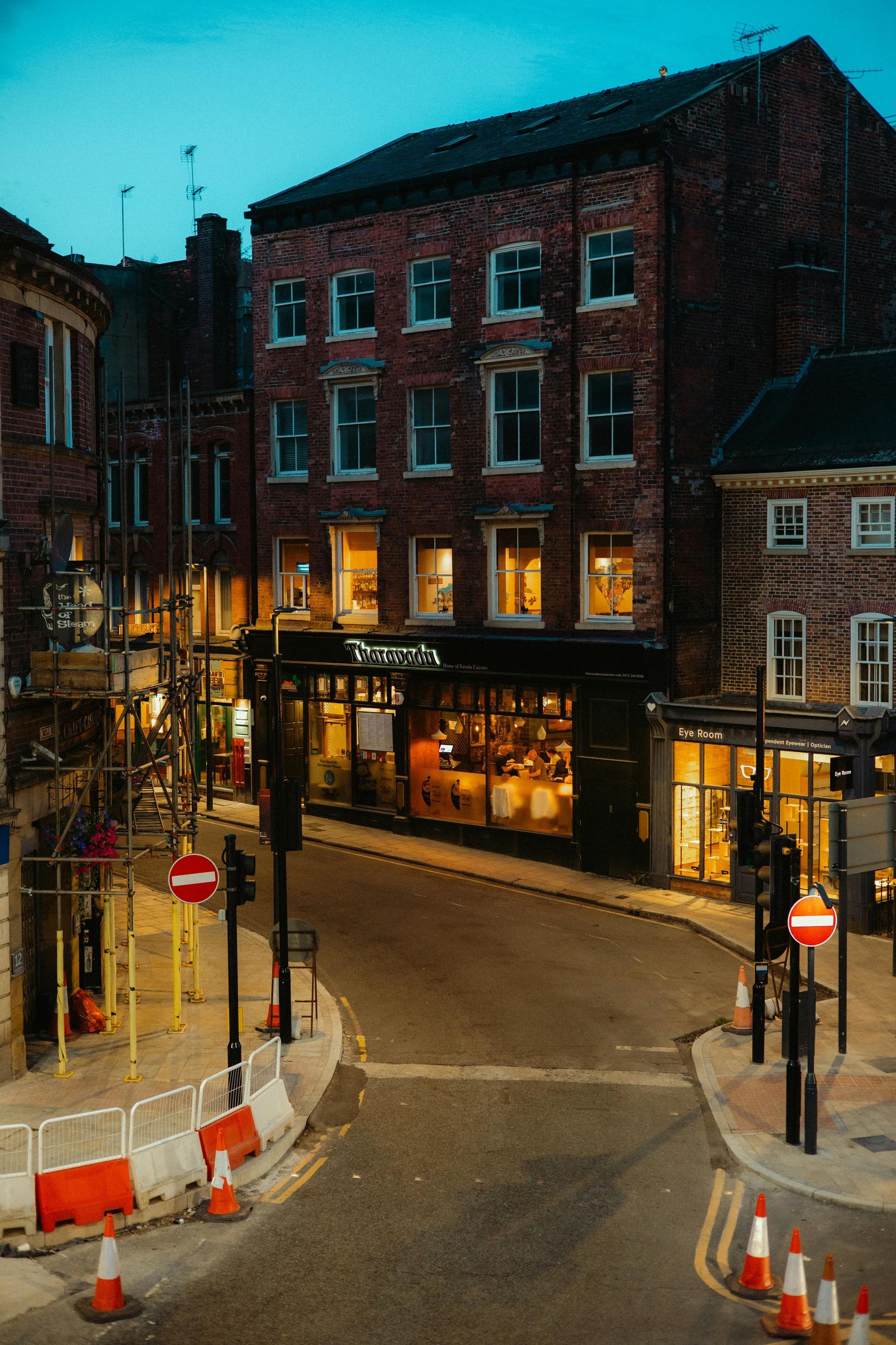 Woman throwing a rock into a lake while a man watches. They stand on a rocky shore.
