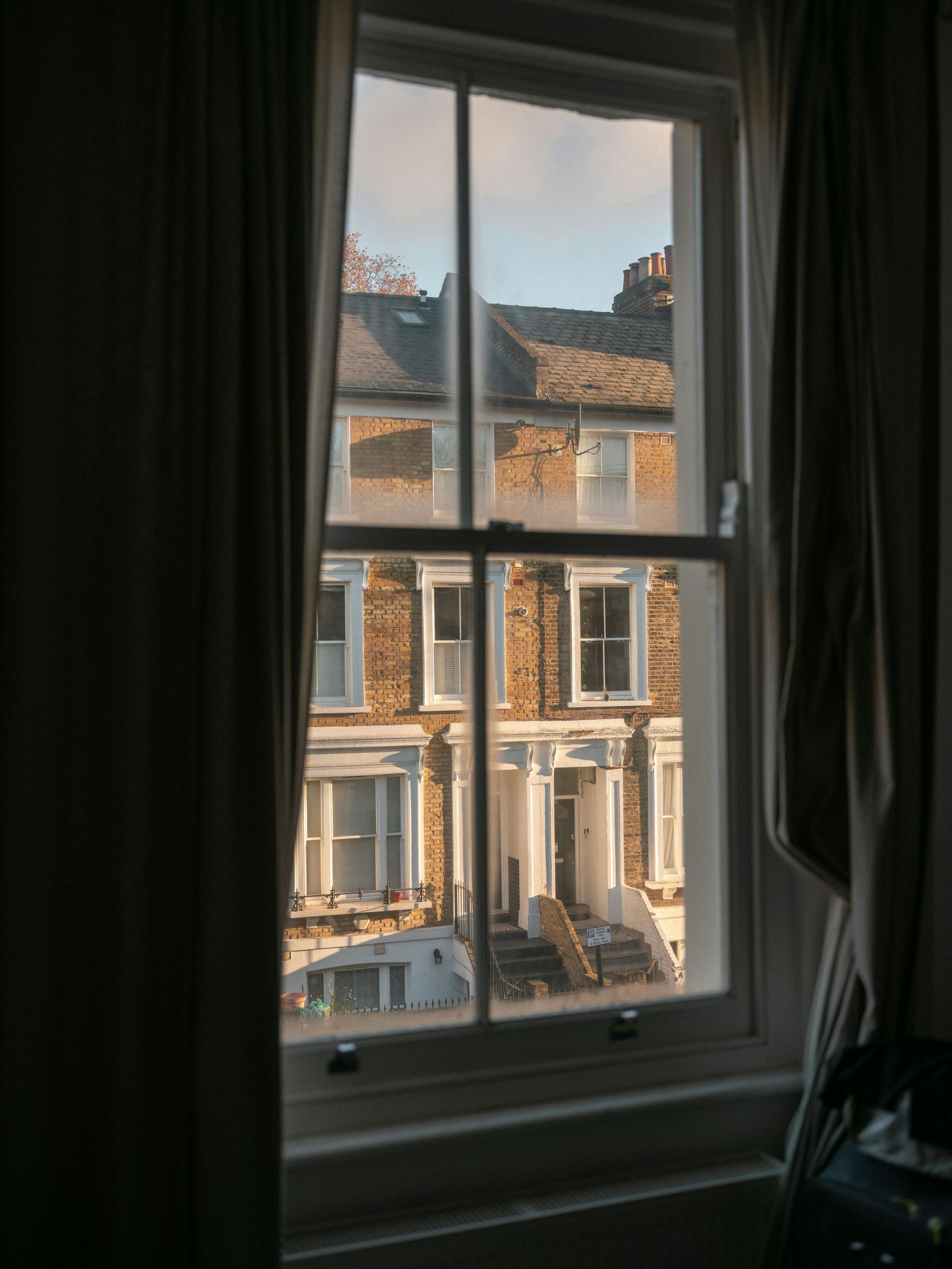 Woman throwing a rock into a lake while a man watches. They stand on a rocky shore.