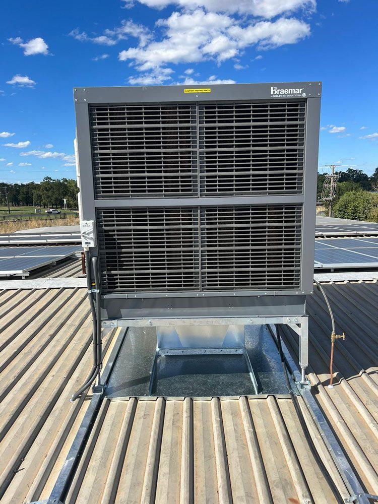 A Large Air Conditioner Is Sitting On Top Of A Roof — Marty Nelson Refrigeration & Air Conditioning In Nyngan, NSW