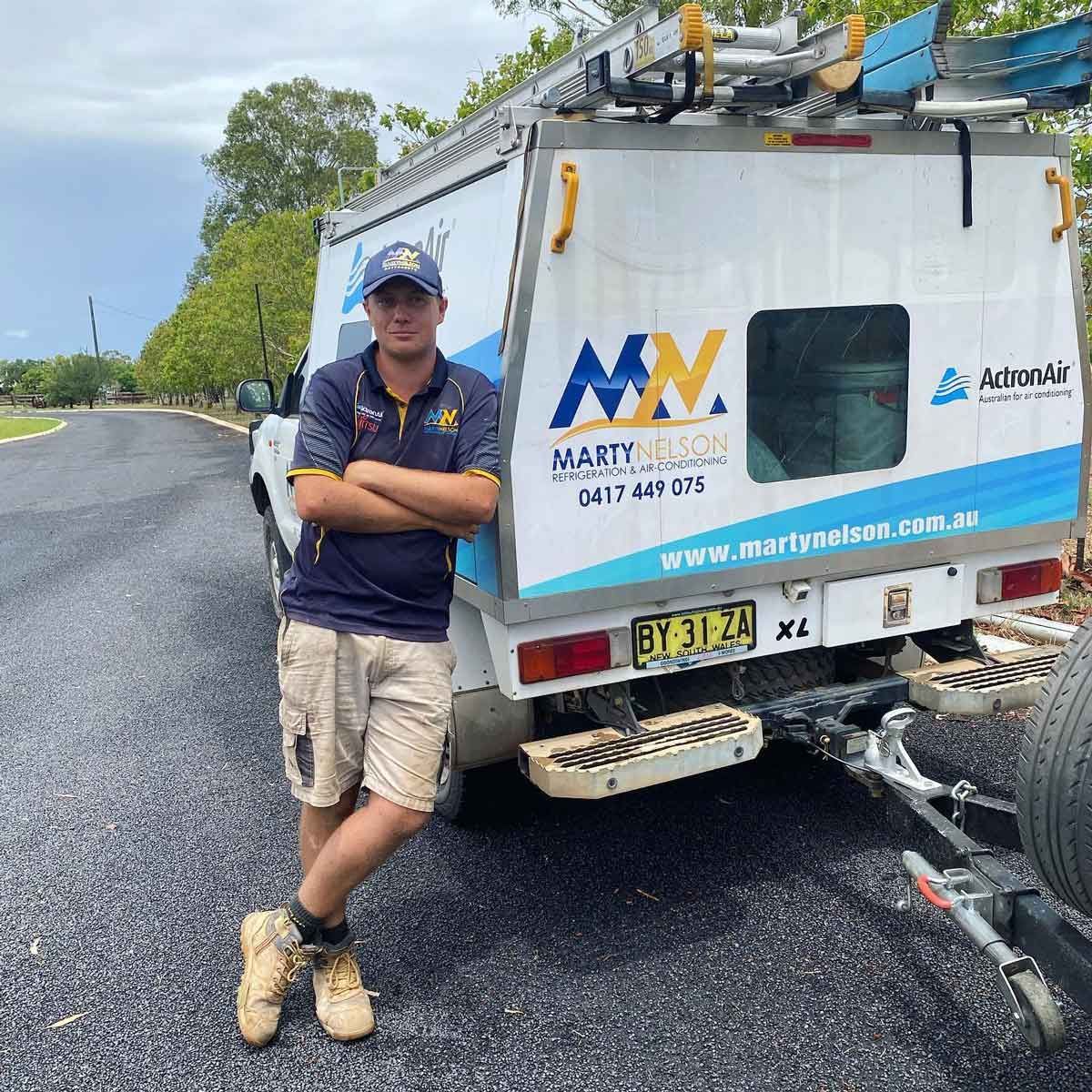 A Man Is Standing In Front Of A Van That Says Mn On It — Marty Nelson Refrigeration & Air Conditioning In Dubbo, NSW