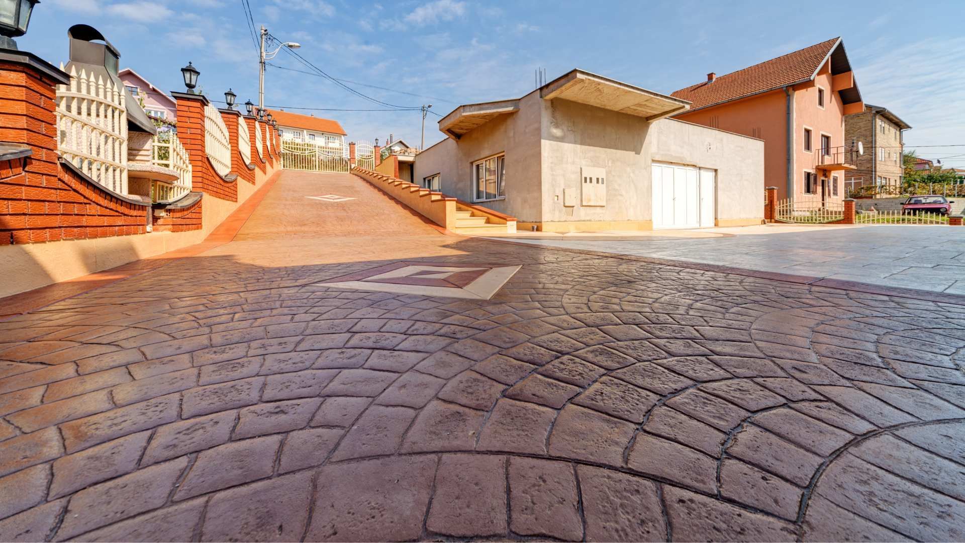 A cobblestone street with a brick wall and stairs leading up to a garage.