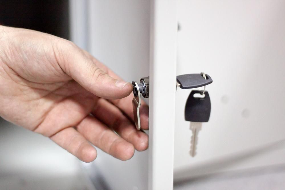 A Person Is Opening a Locker with A Key — Tropical Locksmiths in Gregory River, QLD