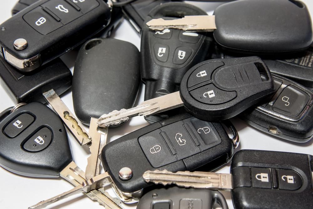 A Pile of Car Keys on A White Surface — Tropical Locksmiths in Cannonvale, QLD