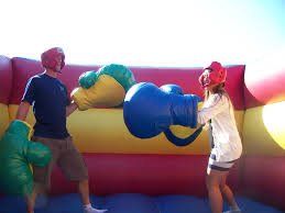 Inflatable boxing ring with oversized gloves for fun sparring.