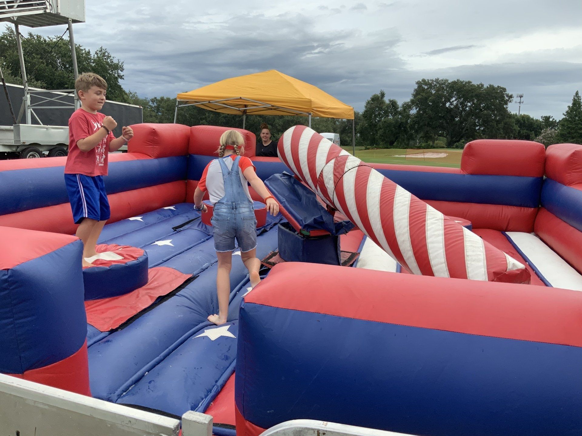 Inflatable game with rotating arms for players to jump and duck.