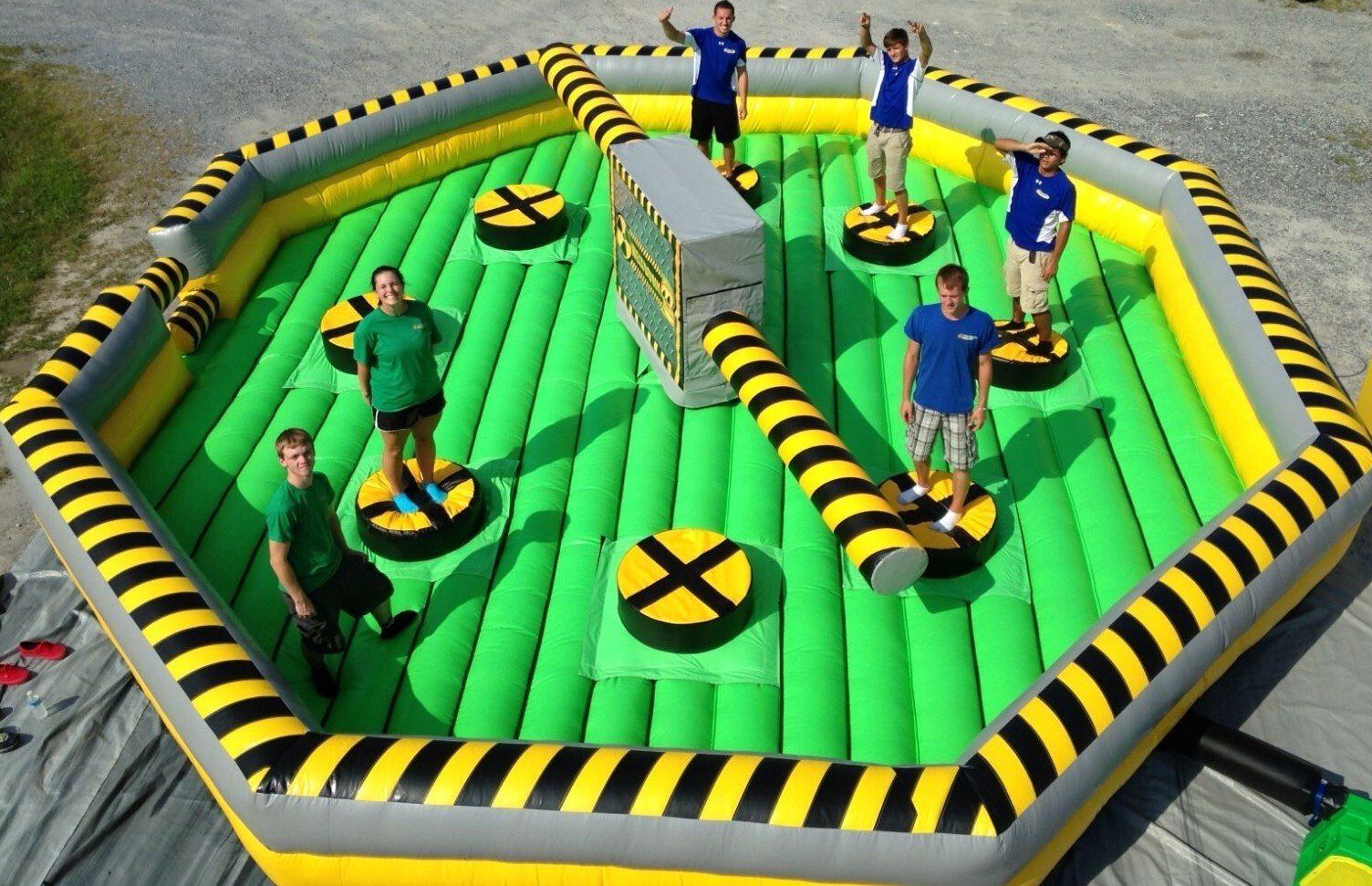 Rotating inflatable challenge where players jump over spinning arms.