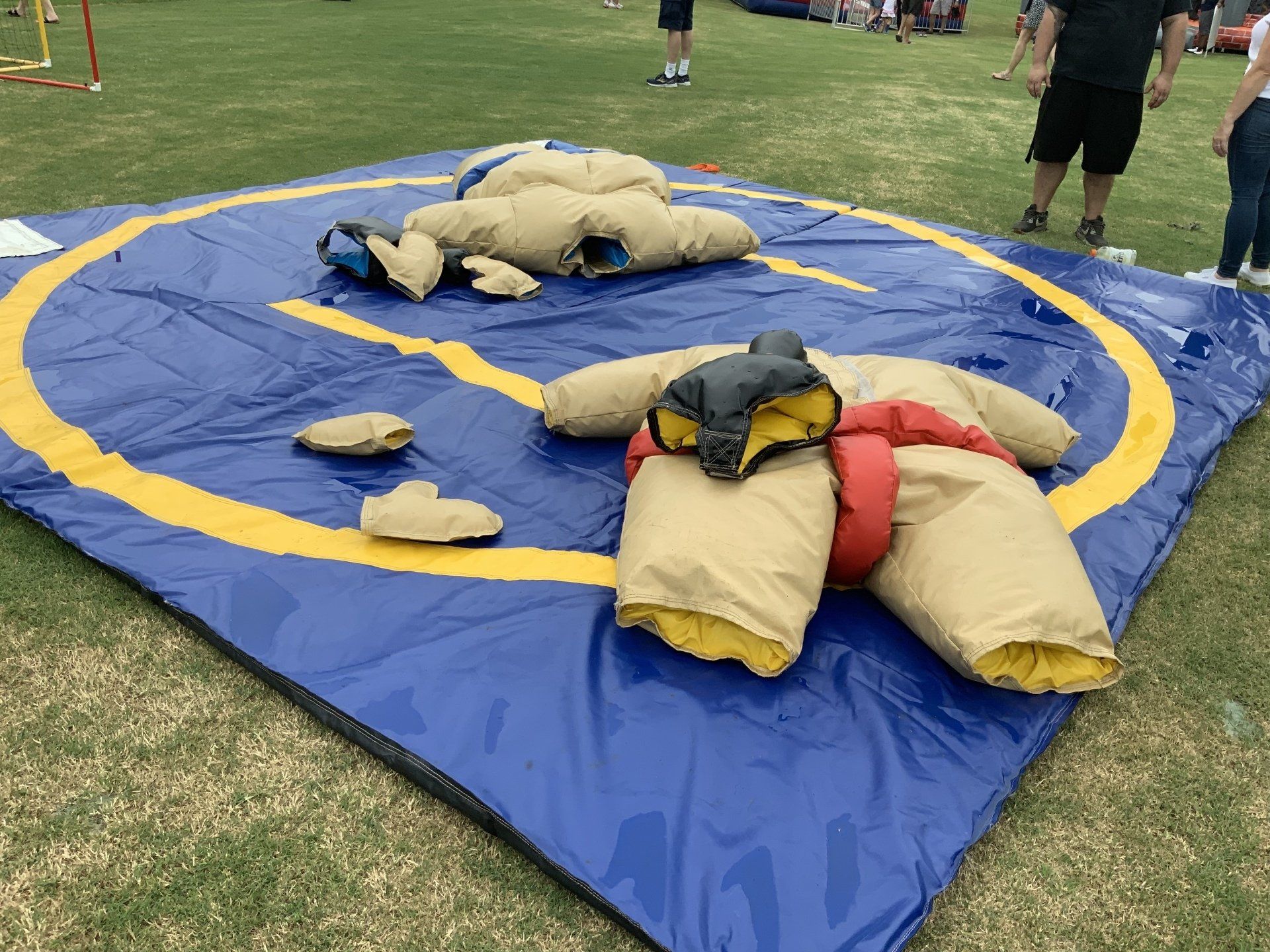 Two people in inflatable sumo suits wrestling.