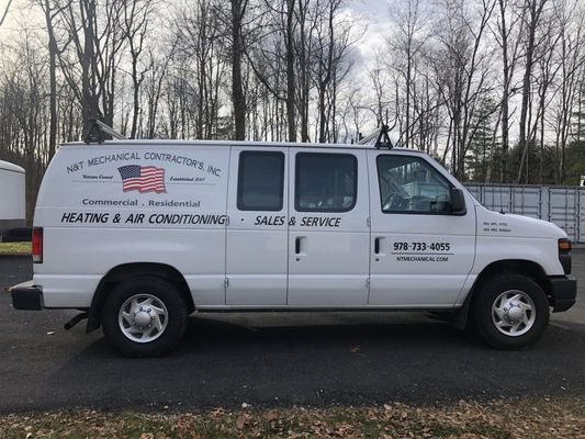 A white service van parked outdoors with professional 