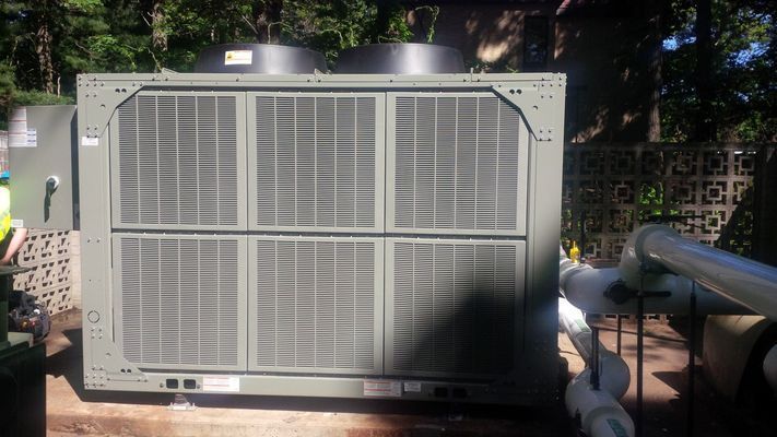 A front-facing view of a large grey industrial HVAC condenser unit with multiple protective grilles.