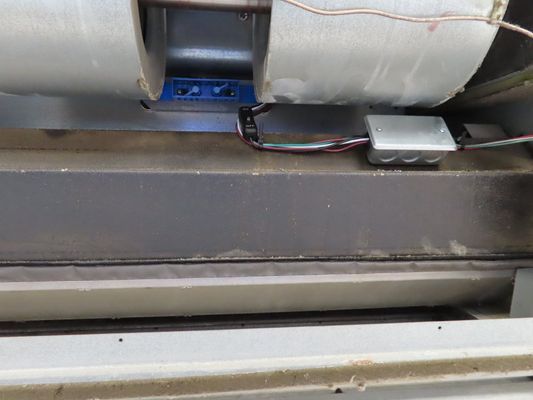 Close-up of the metal blower wheel and internal electrical connections within a commercial air handler.