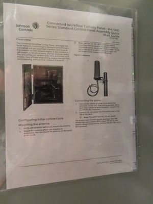 A printed instruction sheet showing a wall-mounted control box and antenna assembly.