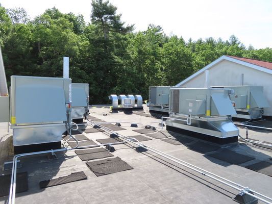 Rooftop mechanical equipment with protective walkway mats.