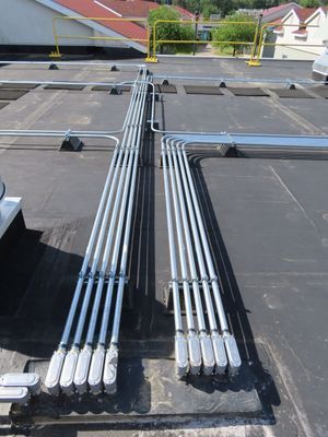 Perspective view of conduit lines converging on a commercial roof.