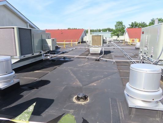 Wide shot of rooftop HVAC units connected by various piping networks.