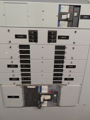 Detail view of a large main electrical breaker panel with multiple switches labeled for different building zones.