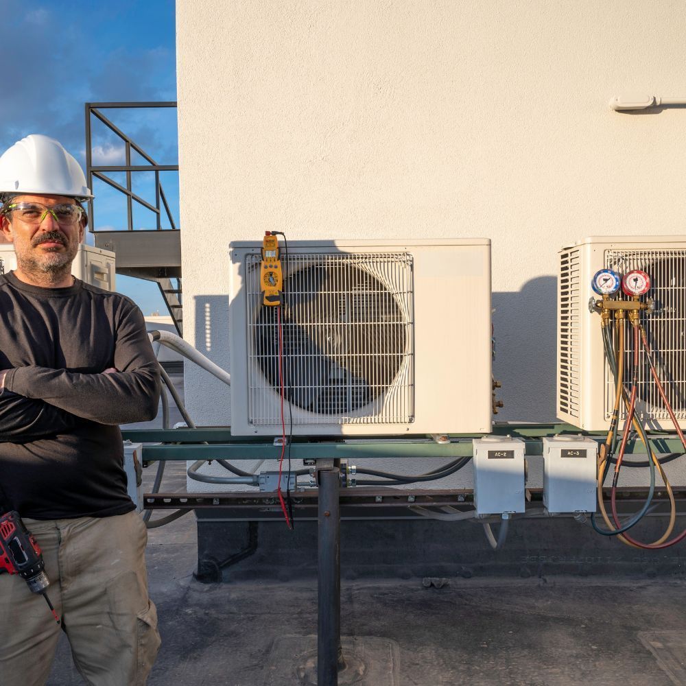 Portrait of an HVAC professional standing by commercial condenser units with testing equipment and gauges.