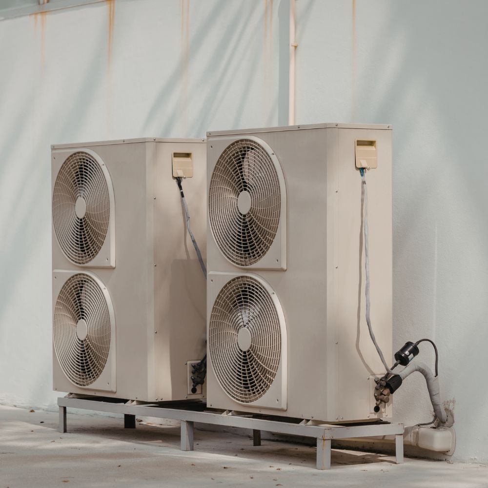A pair of commercial condenser units installed vertically against an exterior wall.