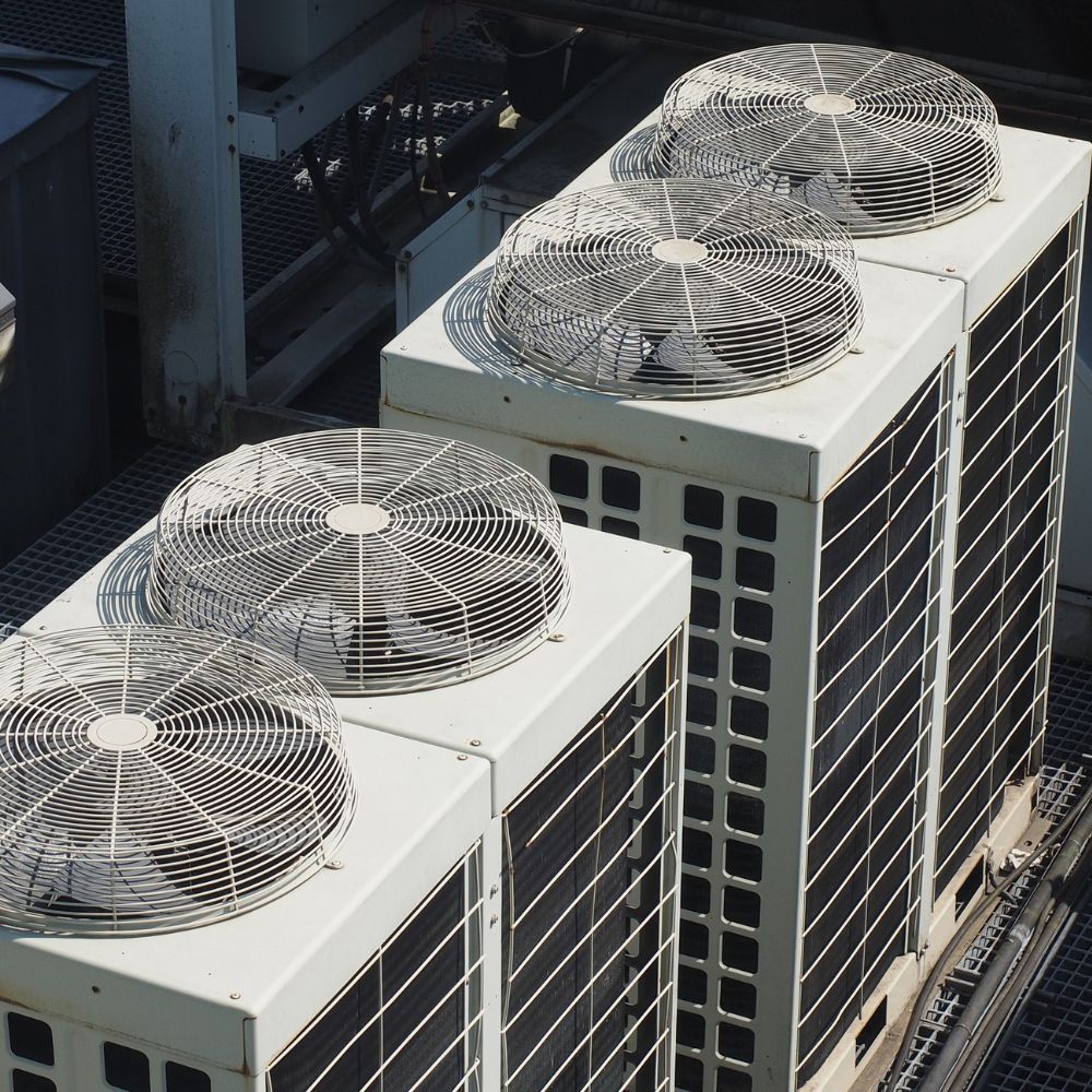 Row of vertically stacked condenser fans providing cooling for a large building.