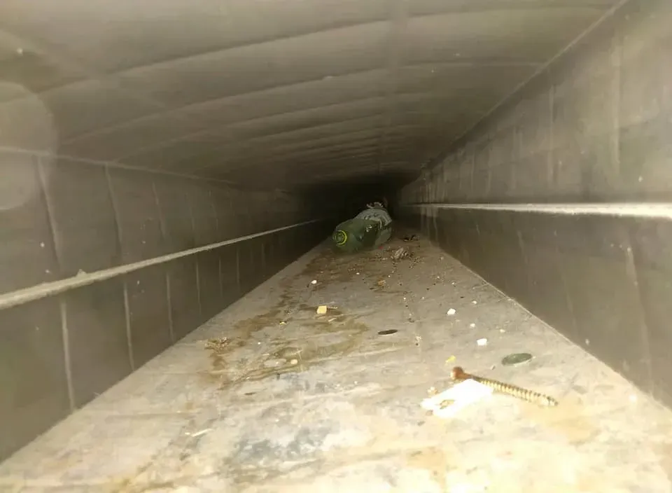 A very long tunnel with a lot of dirt on the floor.