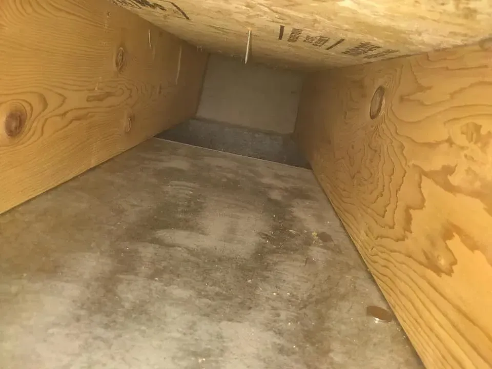 The inside of a wooden box with a concrete floor.