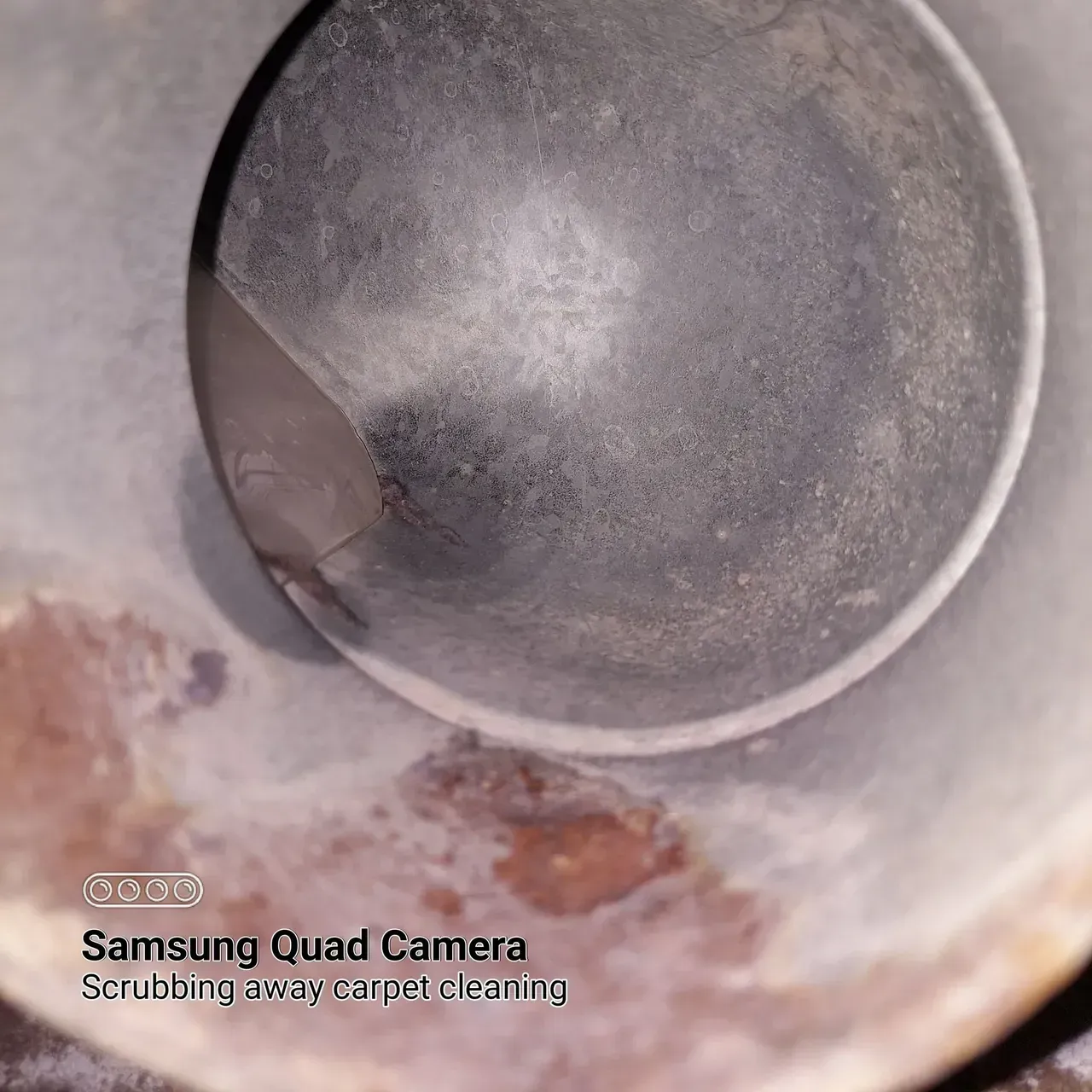 A samsung quad camera is taking a picture of a dirty object