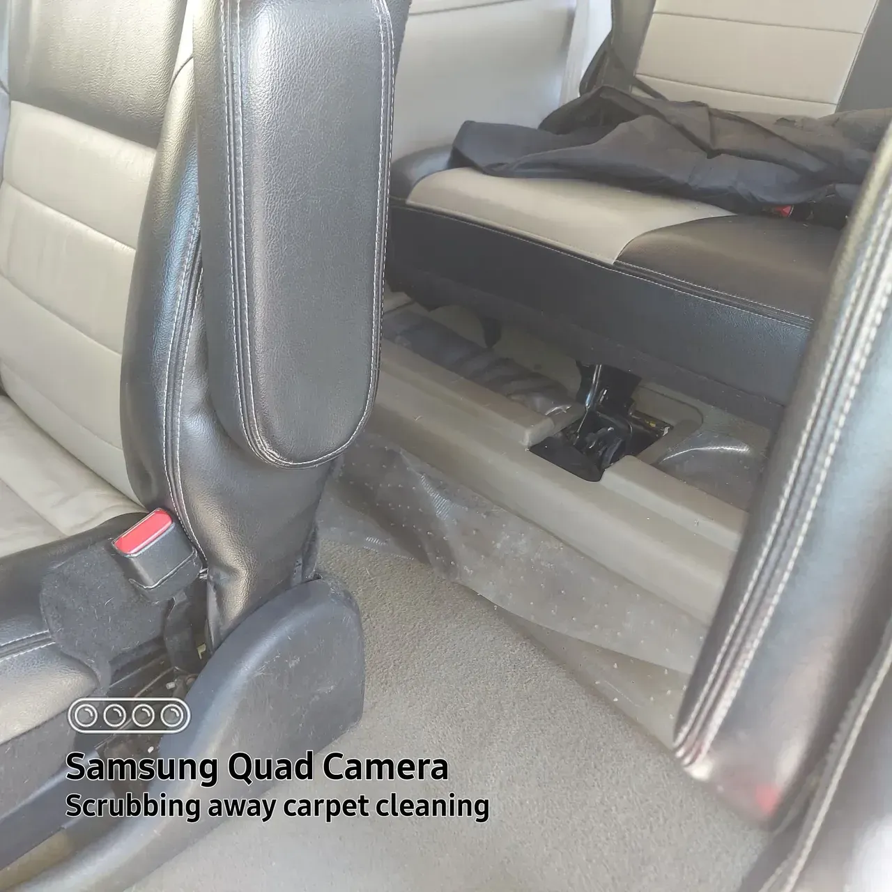 A samsung quad camera is taking a picture of a car seat