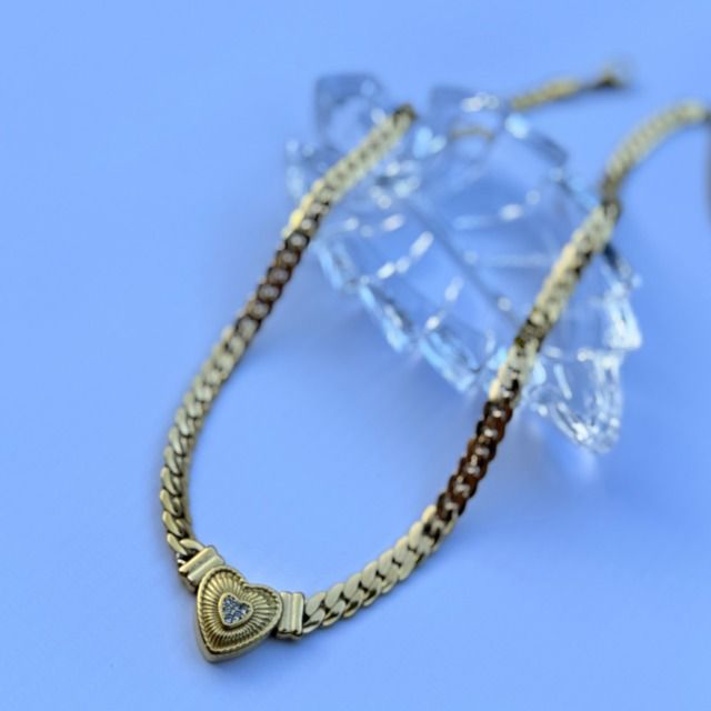 Un collar de cadena de oro con un colgante en forma de corazón.